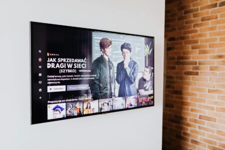 Person watching television shows on streaming platform with remote control