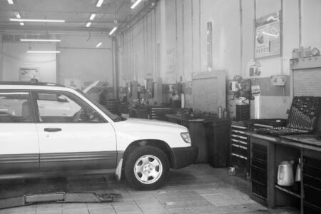 Local Auto Repair Shops Generate Revenue Through Electric Vehicle Conversion Services Interior view of auto repair shop with lifted vehicles and diagnostic equipment