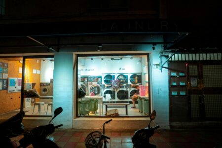 Local Laundromats Generate Revenue Through Package Delivery Hub Services Interior view of modern laundromat with washing machines and package pickup area