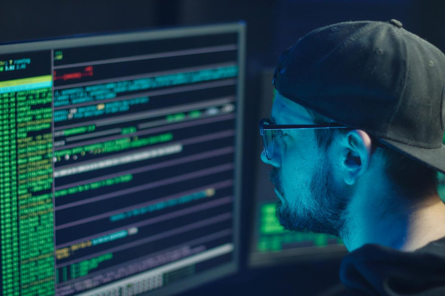Modern office workspace with computer screens displaying cybersecurity monitoring dashboards