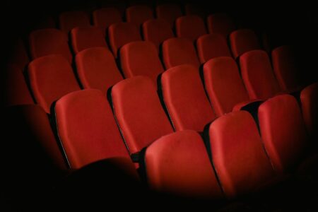Local Movie Theaters Generate Revenue Through Private Screening Rentals Empty movie theater auditorium with red seats and large screen