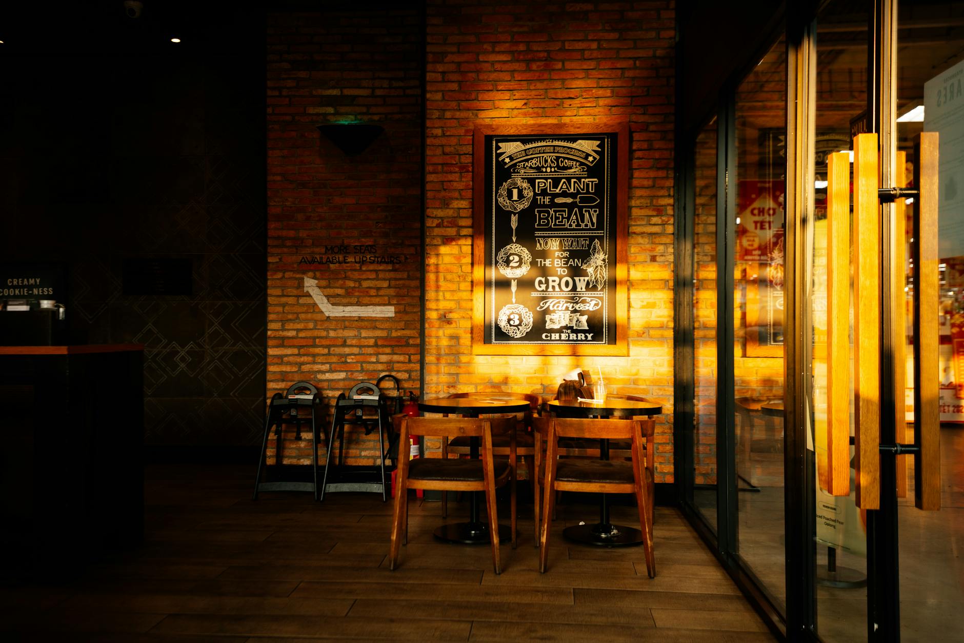 Modern coffee shop interior with tables, chairs, and customers working on laptops