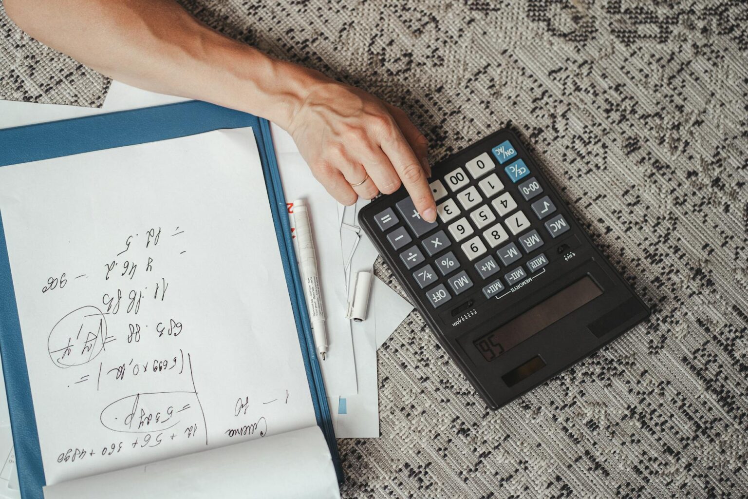Calculator and financial documents on office desk representing tax preparation work