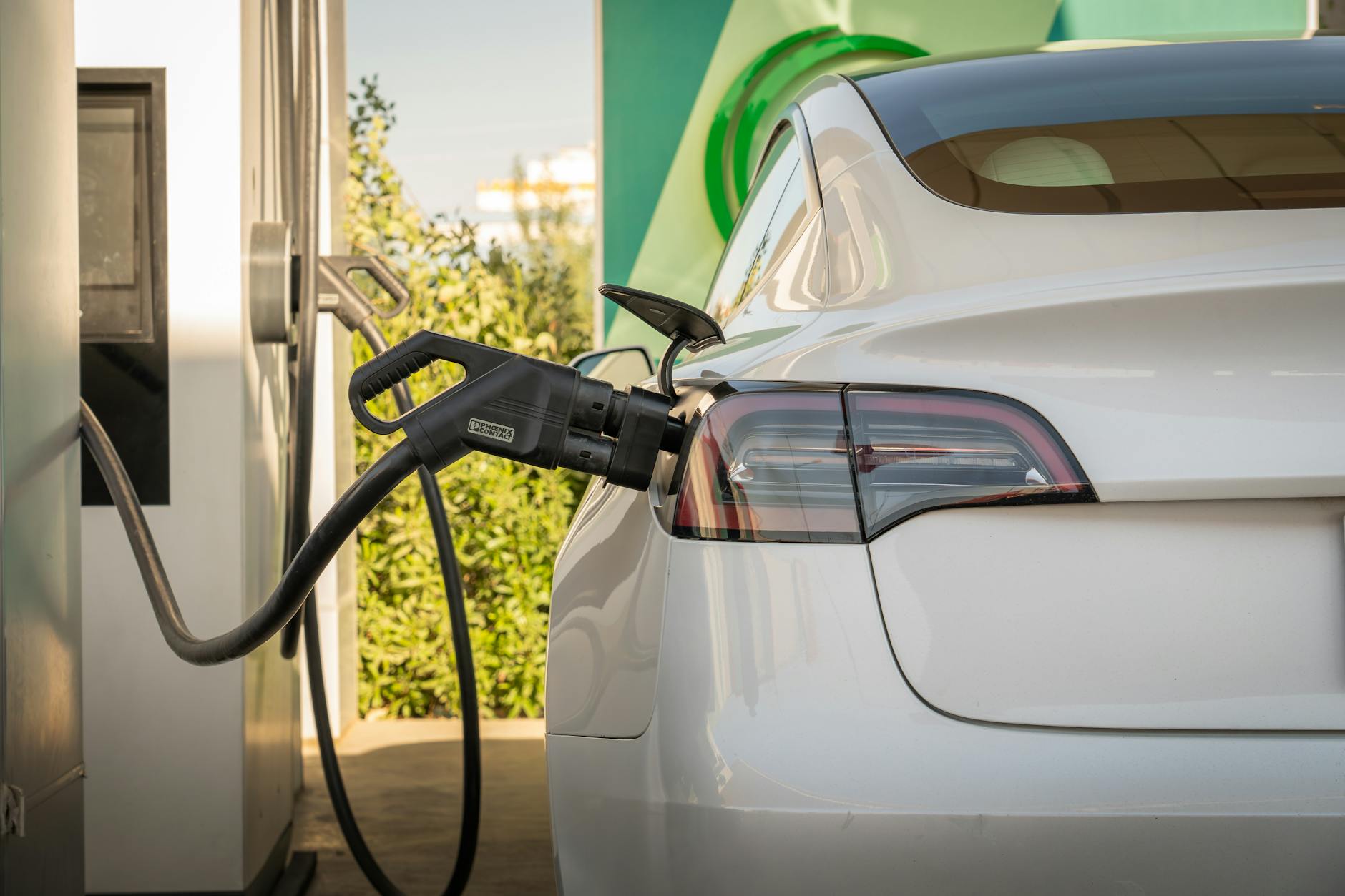 Electric vehicle connected to charging station in urban setting