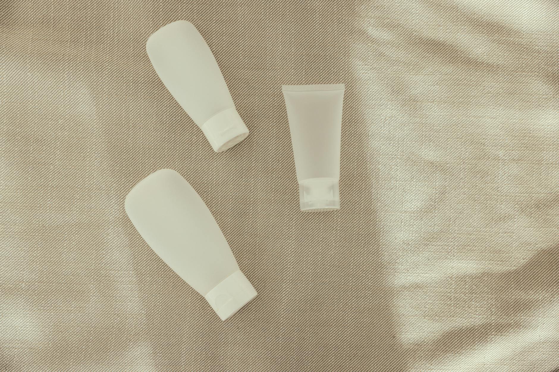 Various beauty product bottles and containers arranged on white surface