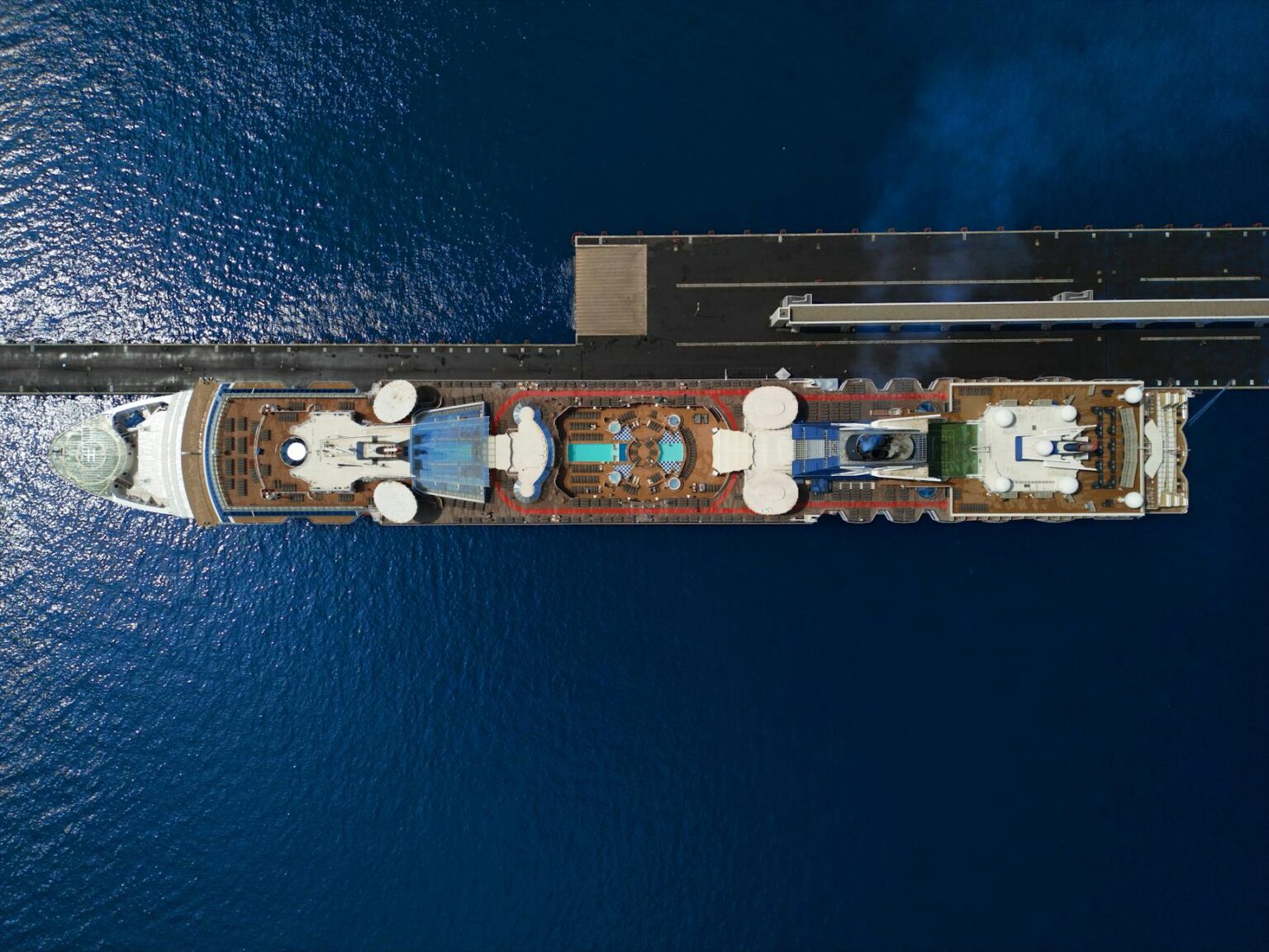 Large cruise ship sailing on open ocean waters under blue sky