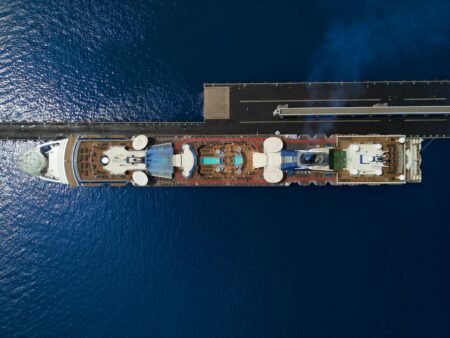 Large cruise ship sailing on open ocean waters under blue sky