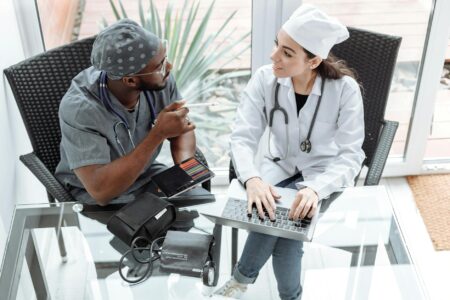 Healthcare professional using laptop for telehealth consultation in medical office