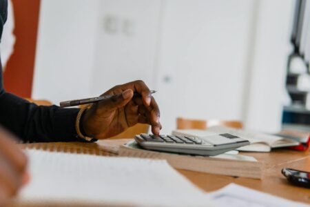Financial calculator and tax documents on desk showing retirement planning calculations