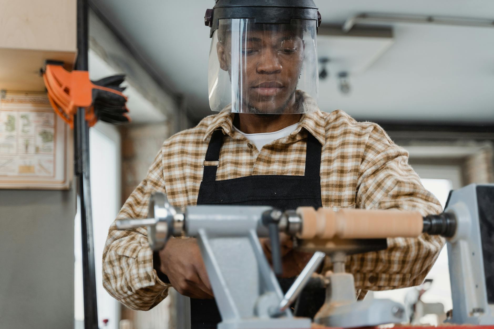 Young worker learning technical skills from experienced mentor in industrial manufacturing setting