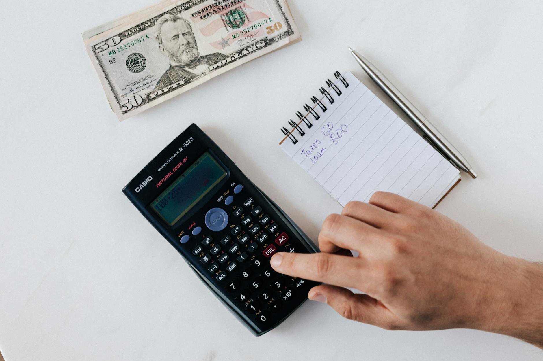 Financial planning materials with calculator and money representing subscription revenue