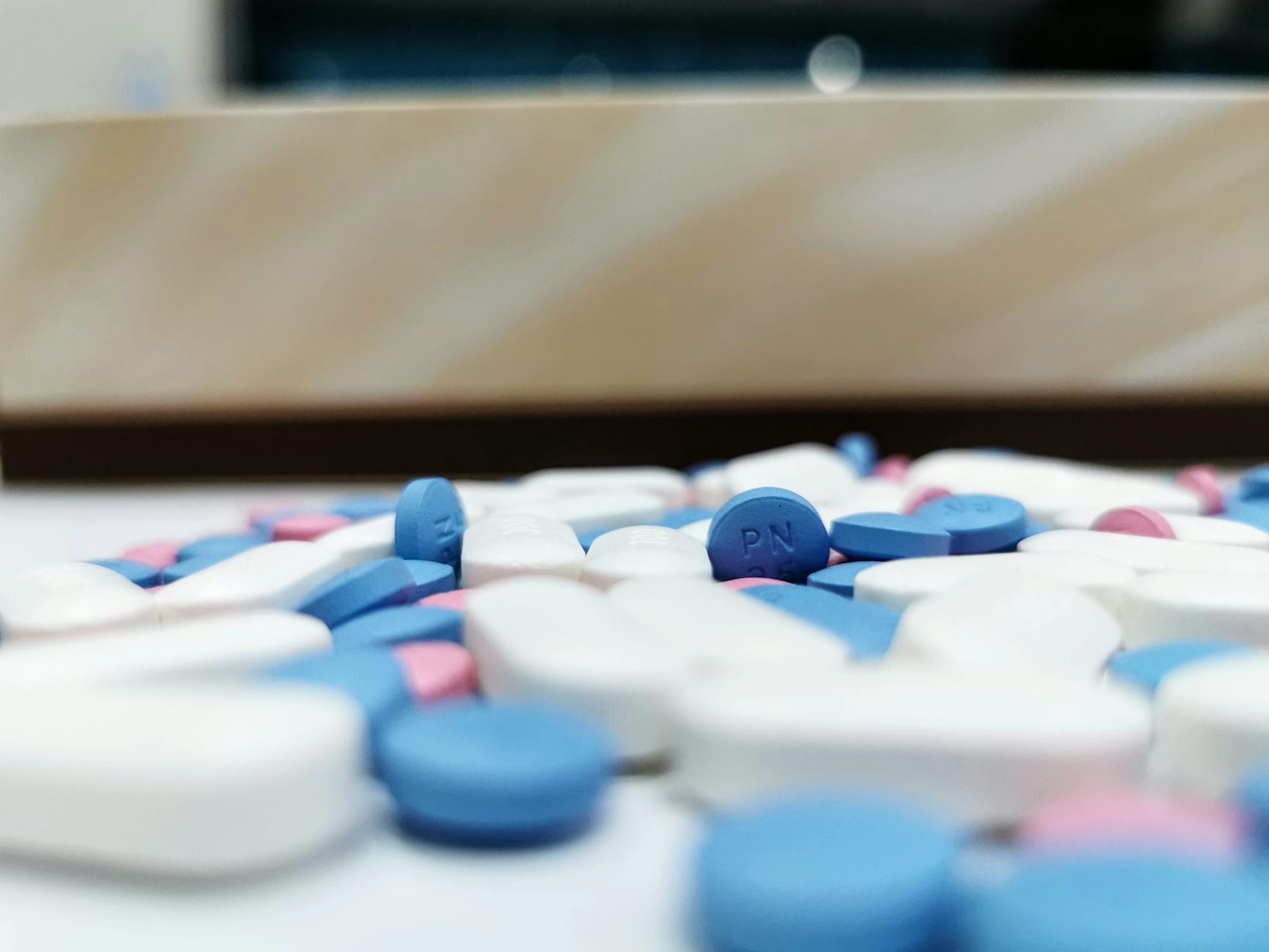 Various pharmaceutical pills and medications arranged on white surface