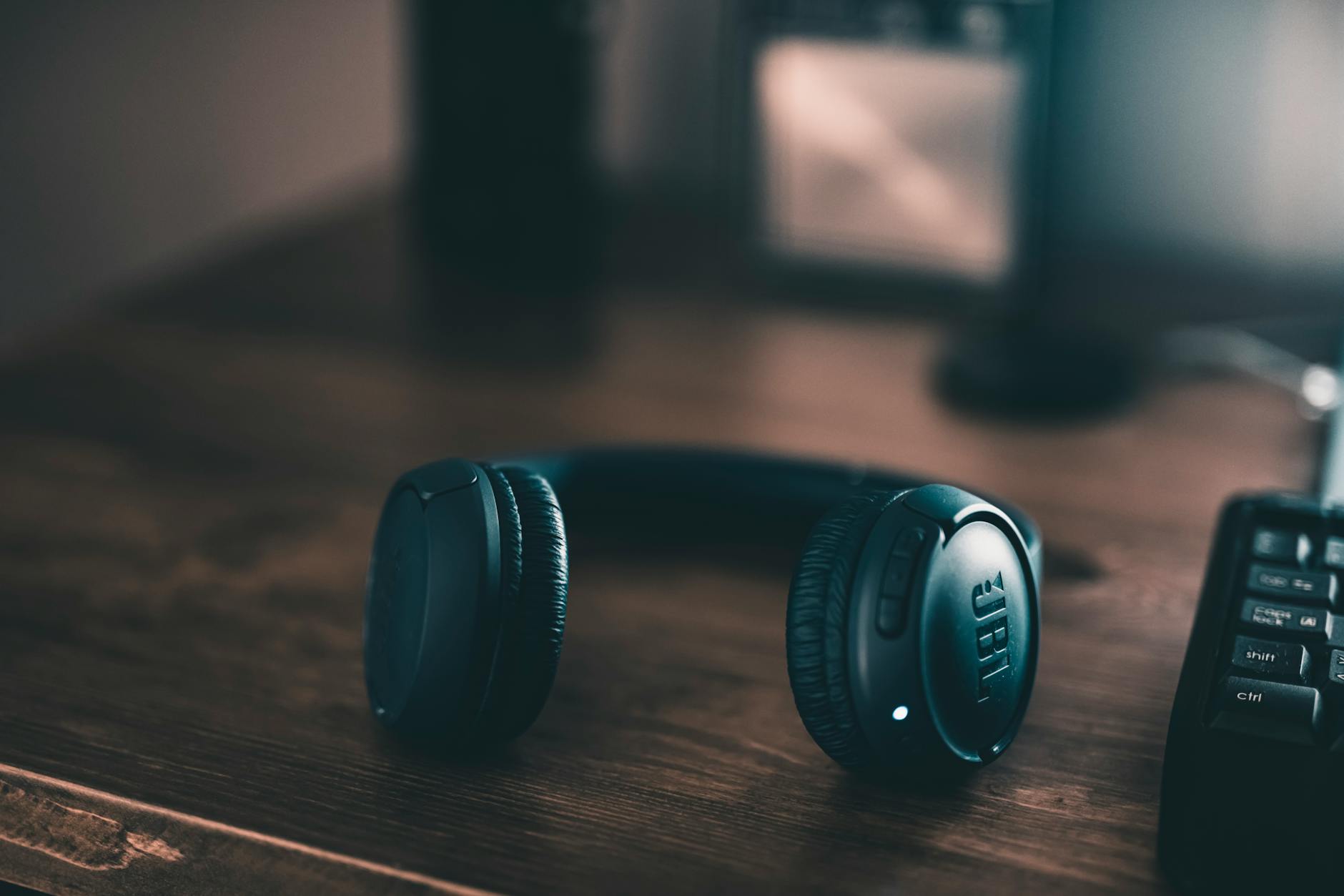 Modern headphones on office desk representing digital audio consumption and podcast listening