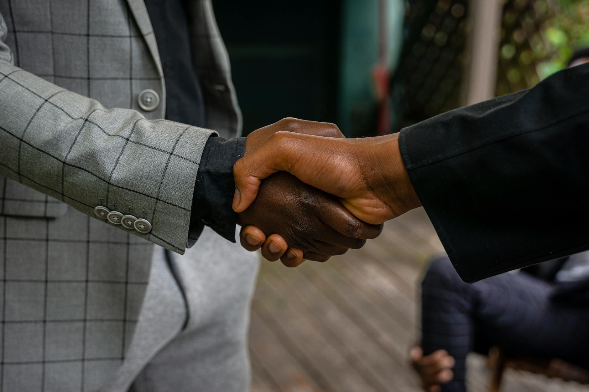 Professional business meeting with people shaking hands over investment documents