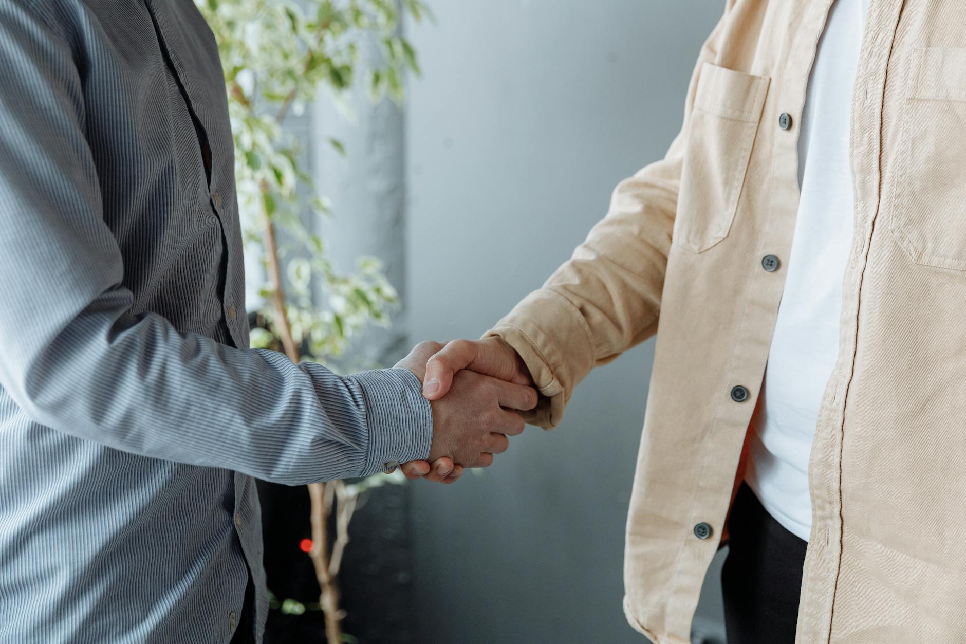 Professional handshake over signed insurance policy documents