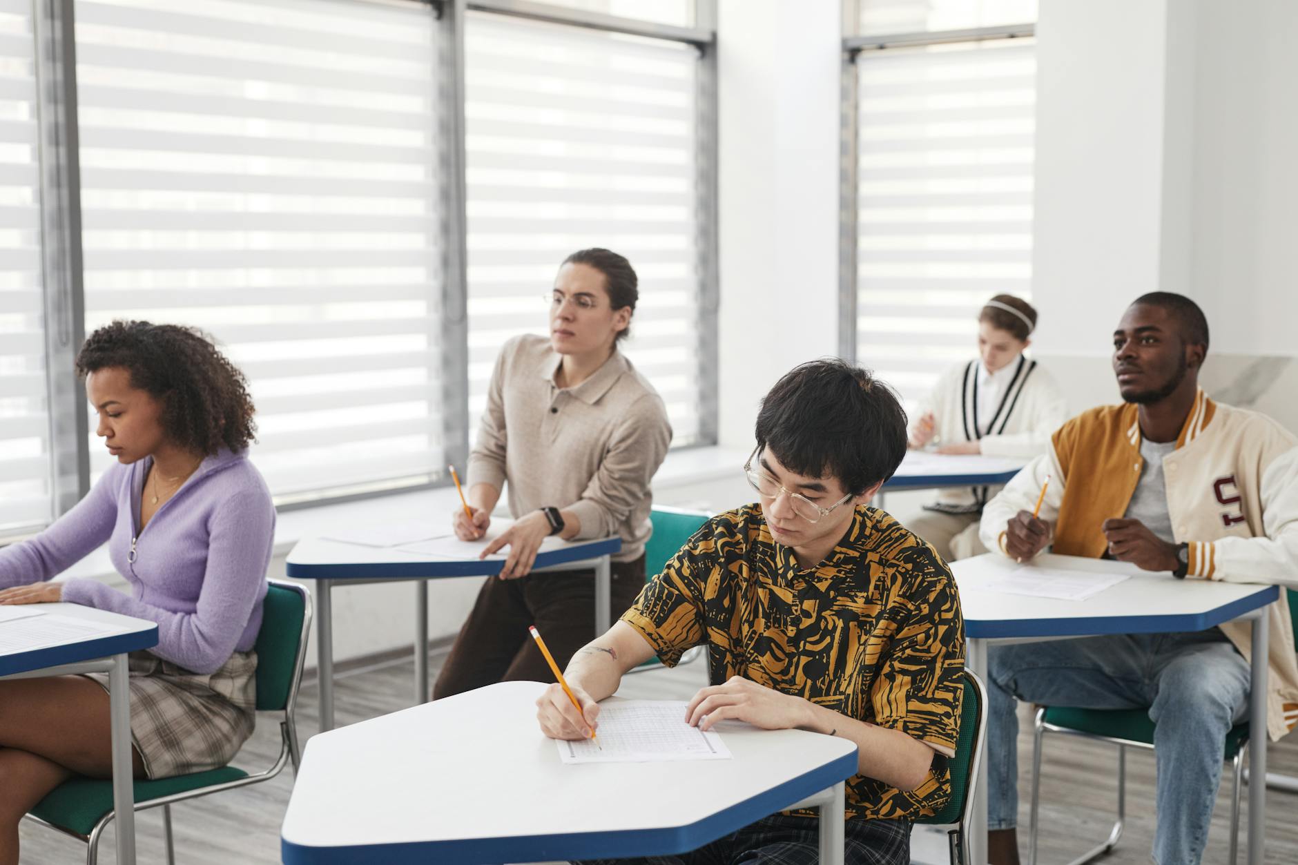 Young student reviewing study materials at a desk in preparation for a standardized test