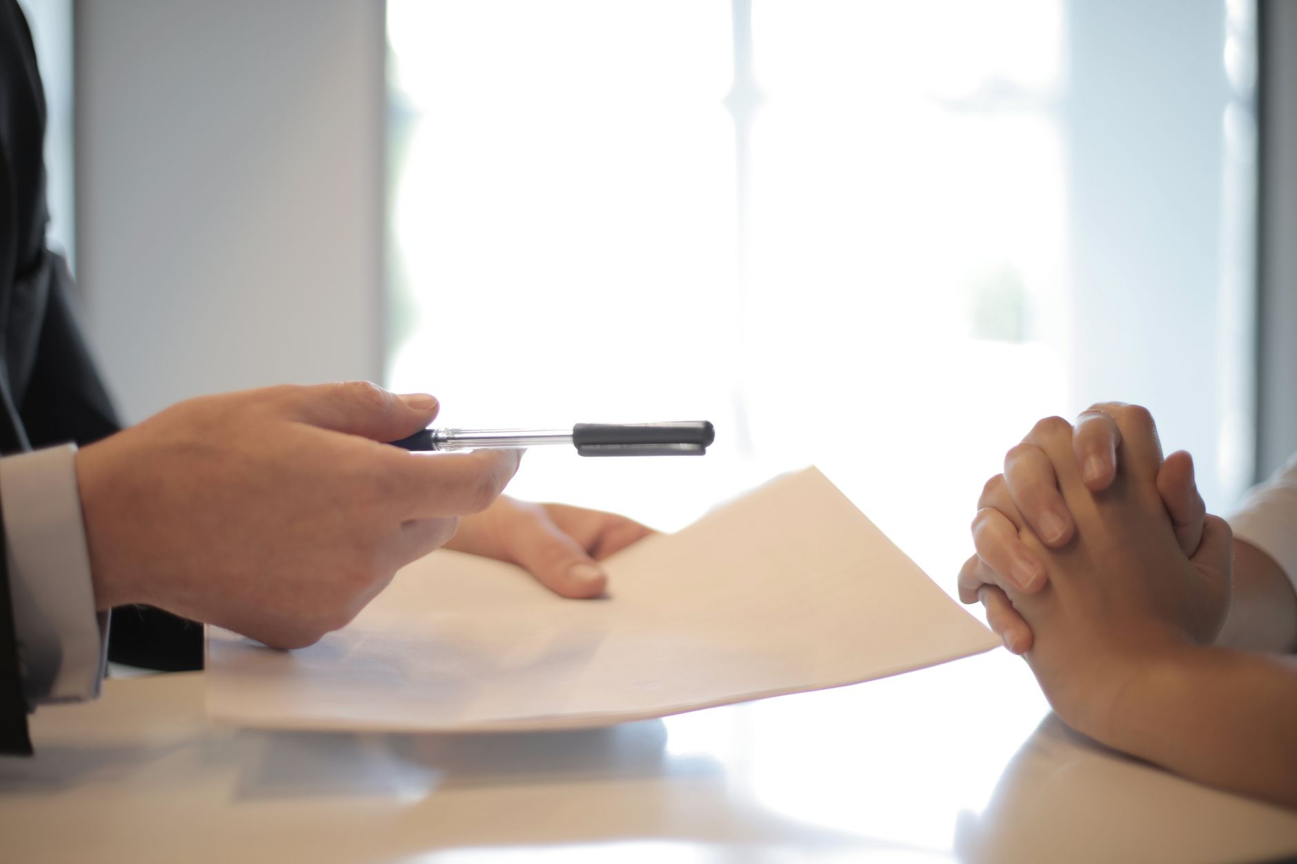 Person signing an insurance or annuity contract with a pen