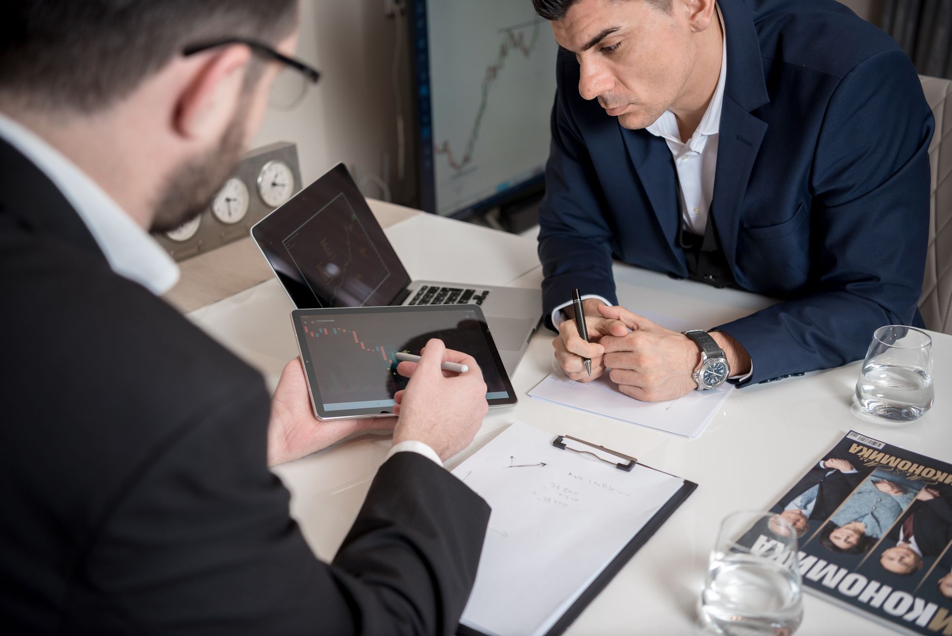 Financial advisor reviewing portfolio documents with a client at a desk
