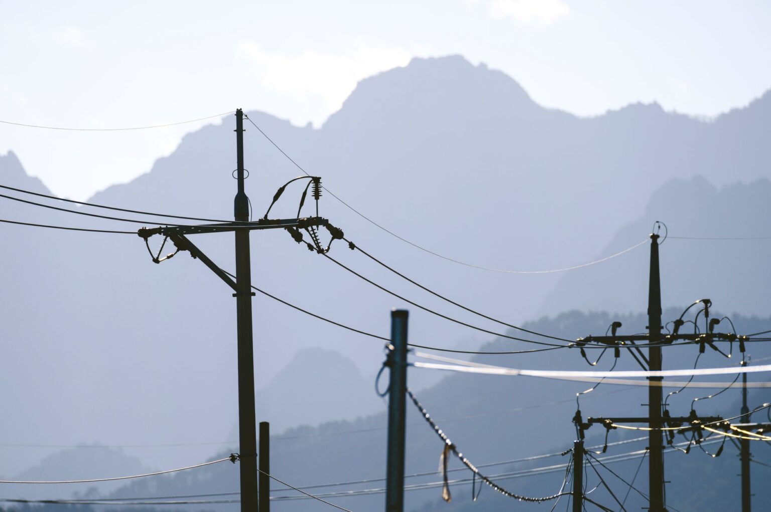 High-voltage electric utility transmission lines against a clear sky