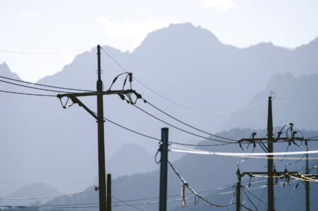 High-voltage electric utility transmission lines against a clear sky