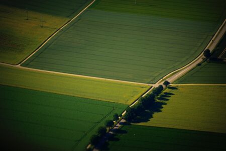 Aerial view of green agricultural farmland stretching across flat terrain