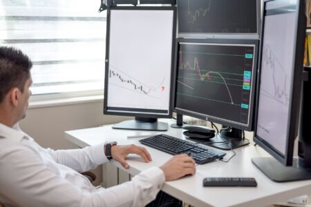 Multiple financial trading screens displaying commodity futures and market data