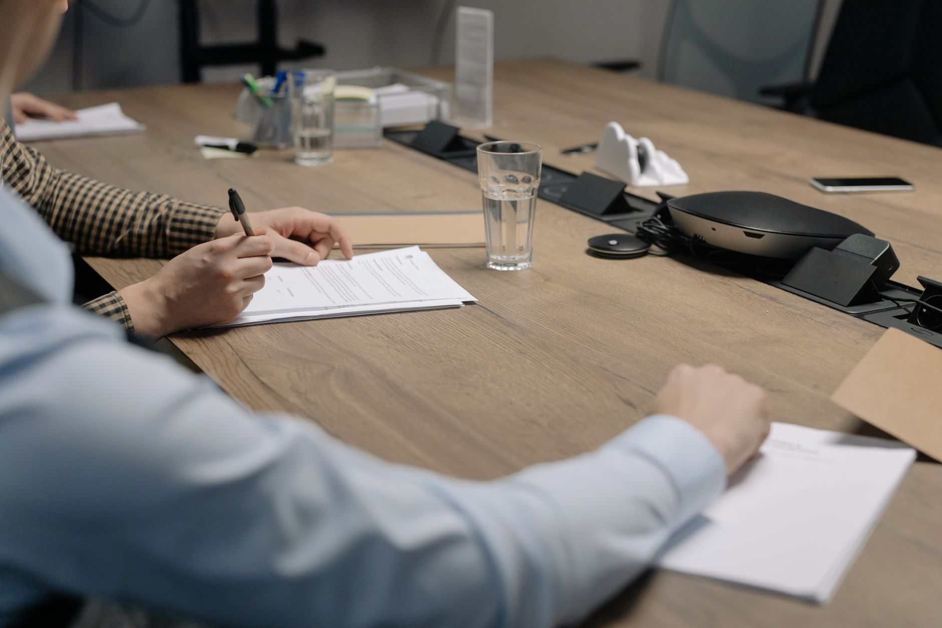 Business professionals reviewing documents at a corporate deal meeting