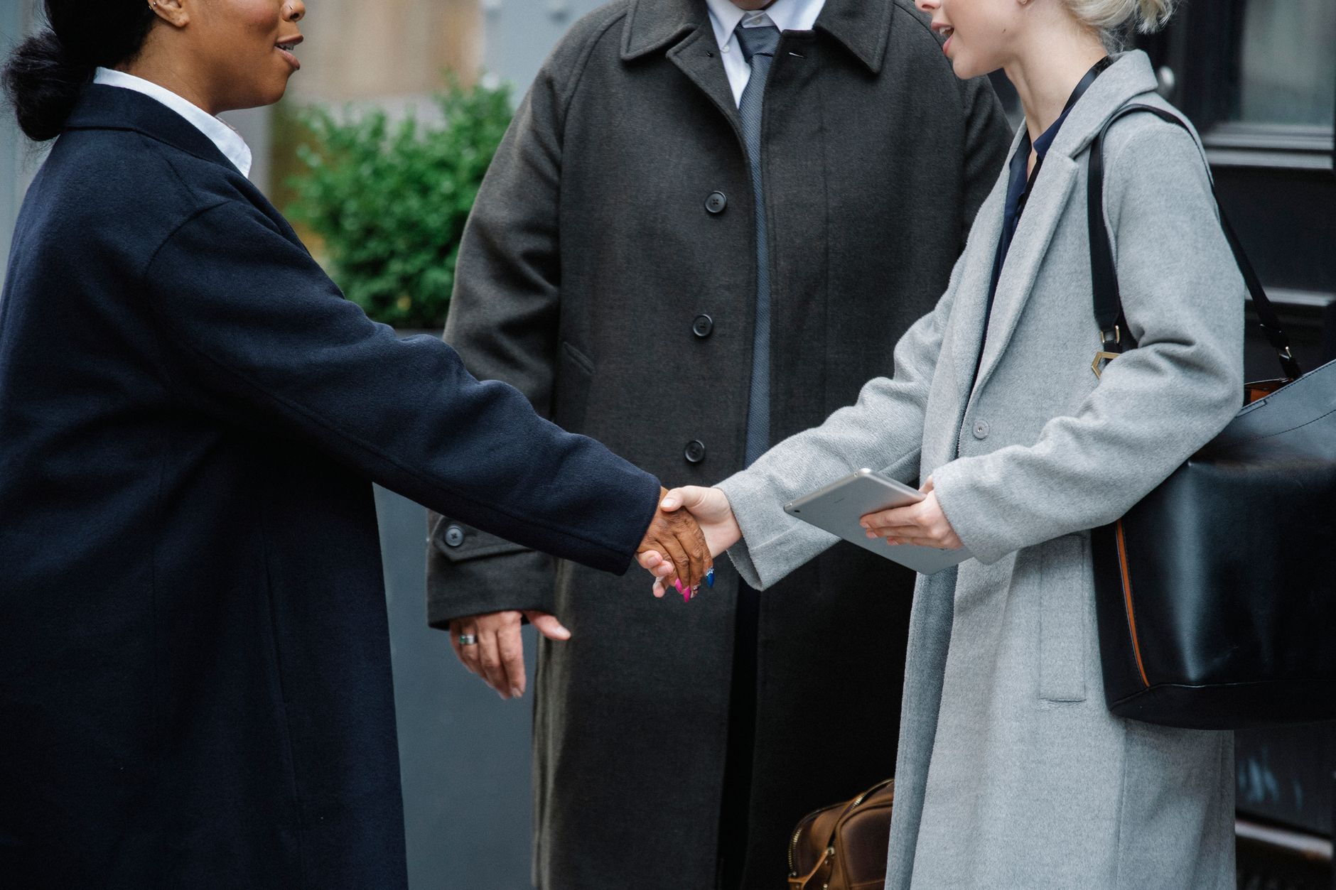 Two professionals shaking hands in a business meeting representing a secondary market transaction