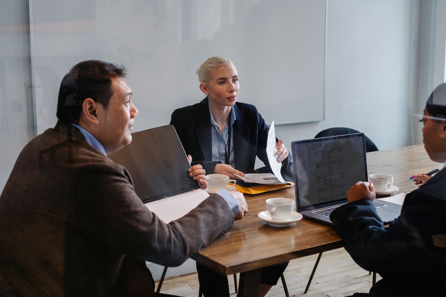 Financial professionals reviewing structured investment documents at a conference table
