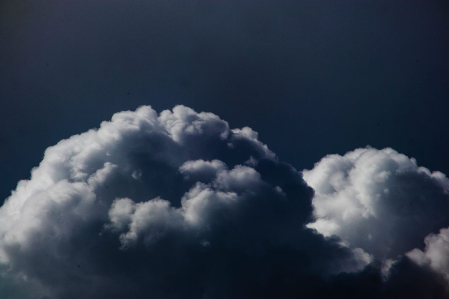Reinsurance Sidecars Quietly Attract Capital as Cat Losses Mount Dark storm clouds viewed from above representing catastrophe risk in reinsurance markets