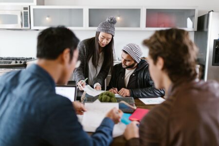 Secondaries Market for Private Credit Quietly Draws New Allocators Business professionals reviewing financial documents in a private equity meeting setting