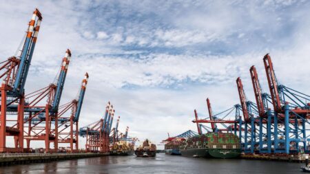 Commodity Trade Finance Funds Quietly Draw Yield-Hungry Allocators Large cargo containers stacked at an industrial shipping port, representing global commodity trade flows
