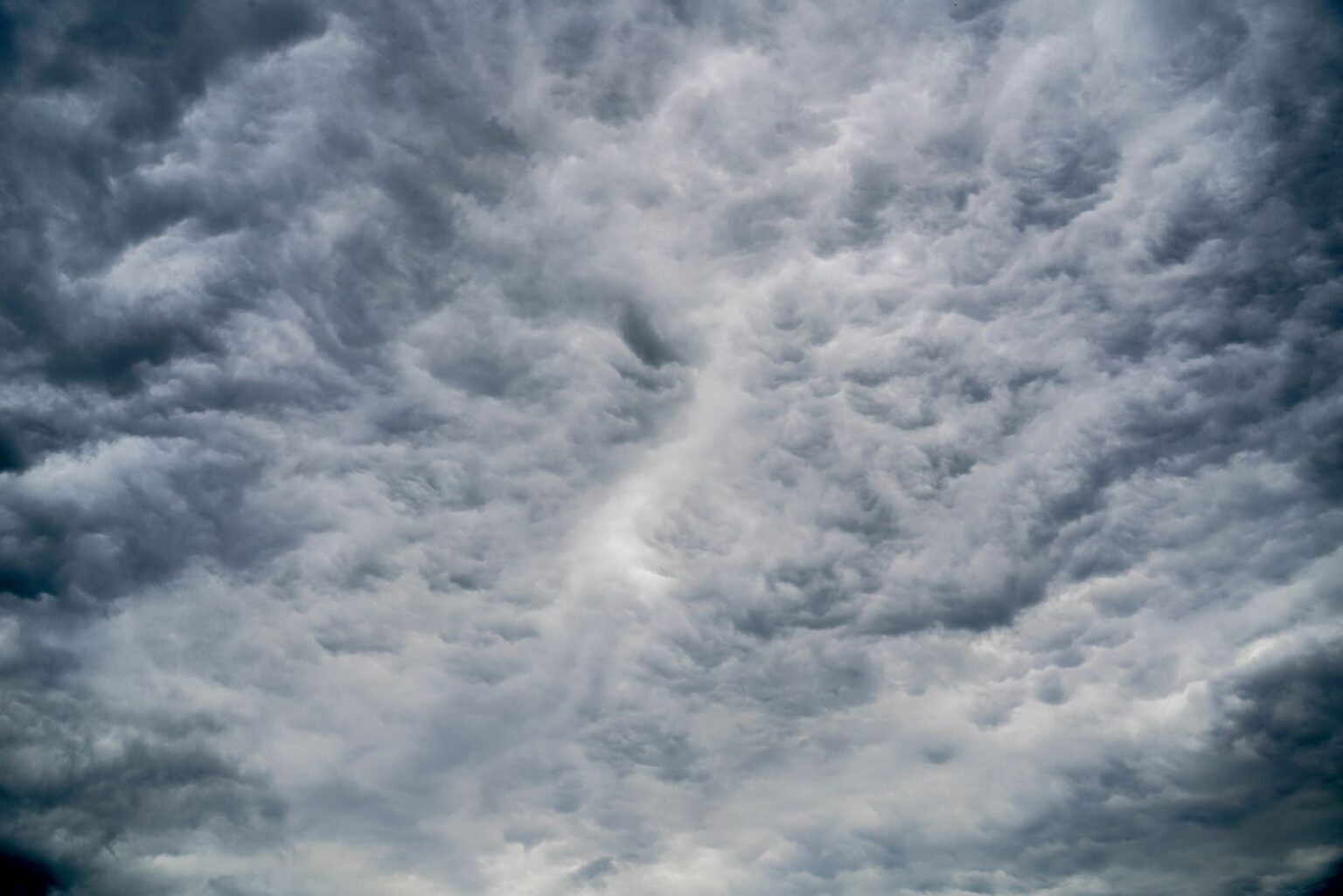 Aerial view of dark storm clouds forming over open landscape, representing catastrophe weather risk