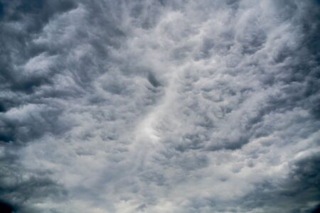 Aerial view of dark storm clouds forming over open landscape, representing catastrophe weather risk