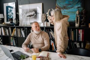 Older couple reviewing financial documents at a table, planning for retirement