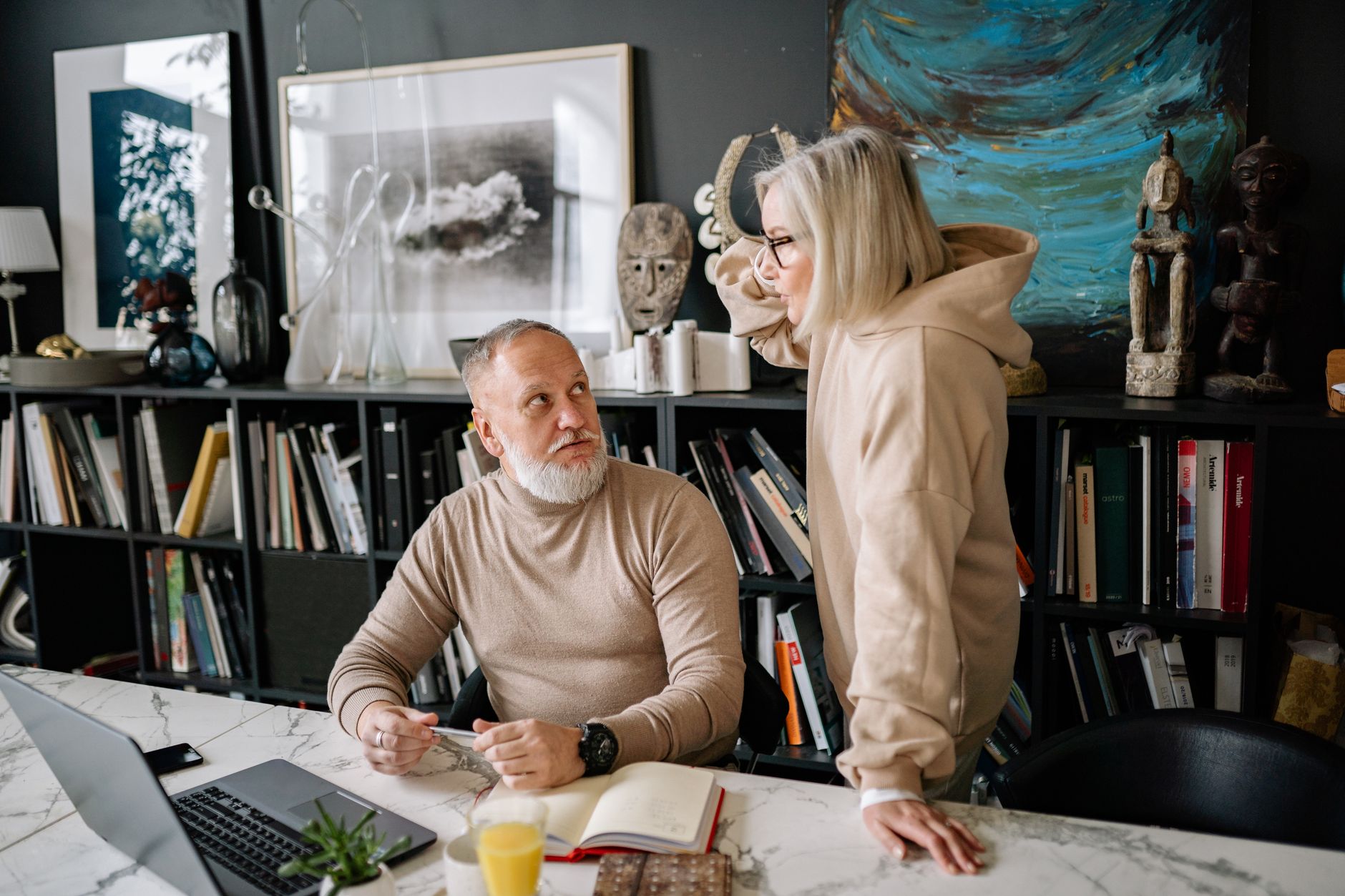 Older couple reviewing financial documents at a table, planning for retirement