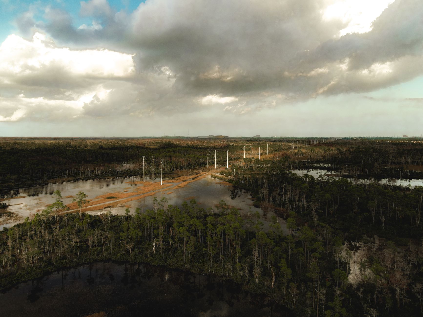 Aerial view of electrical power grid transmission lines crossing open terrain
